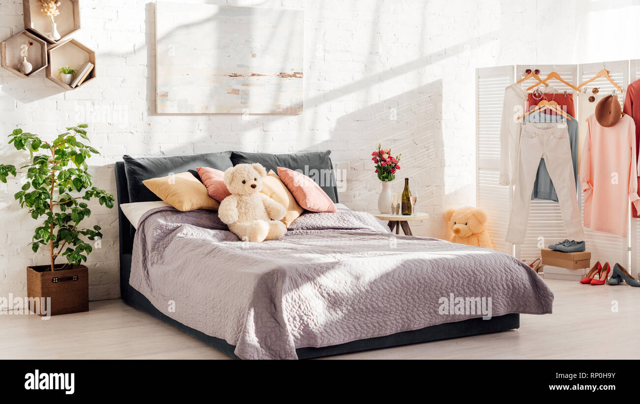 modern interior design of bedroom with teddy bear toys, pillows, plants and bed Stock Photo