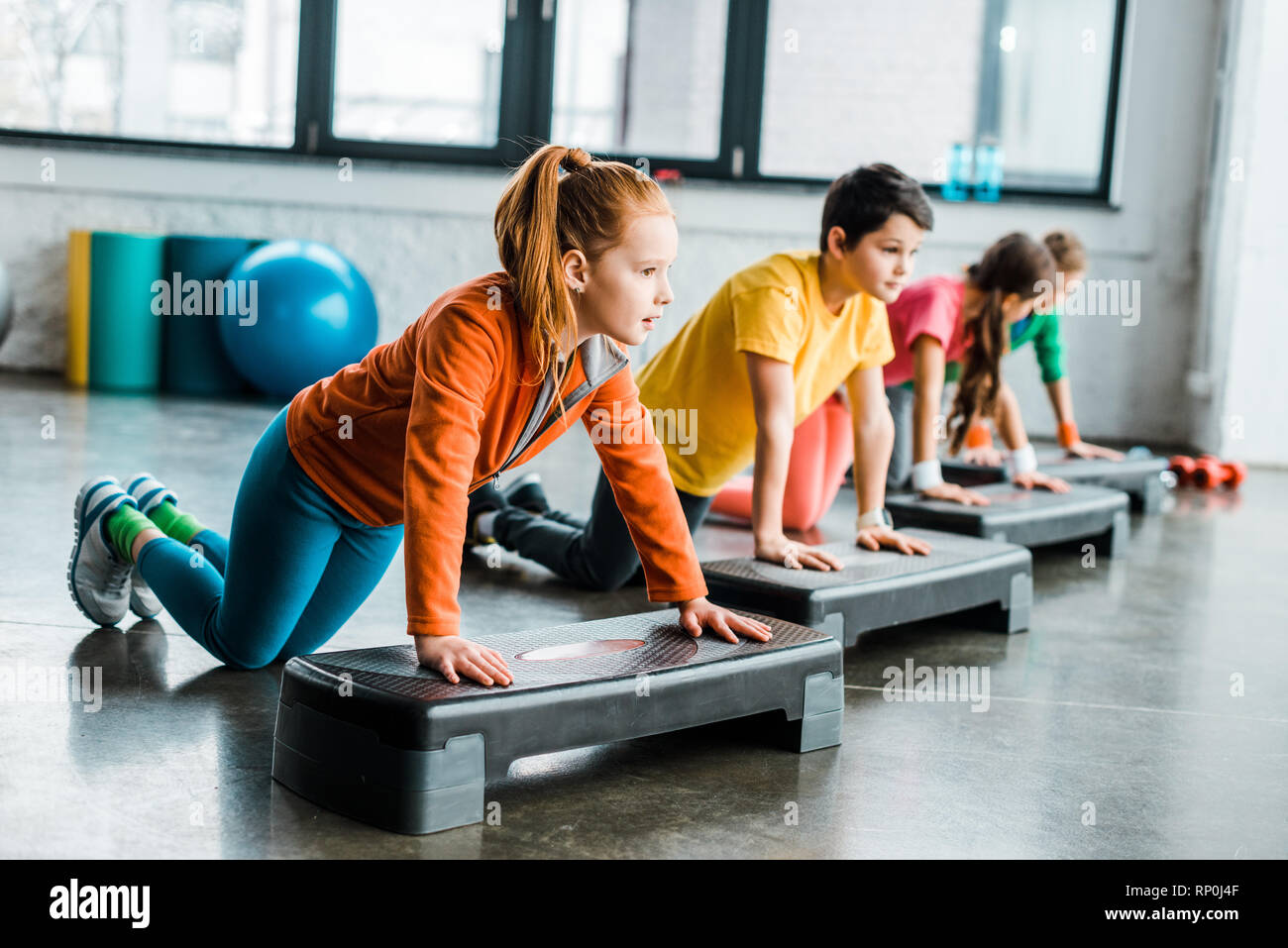 Kids using step platforms while doing push up exercise Stock Photo Alamy
