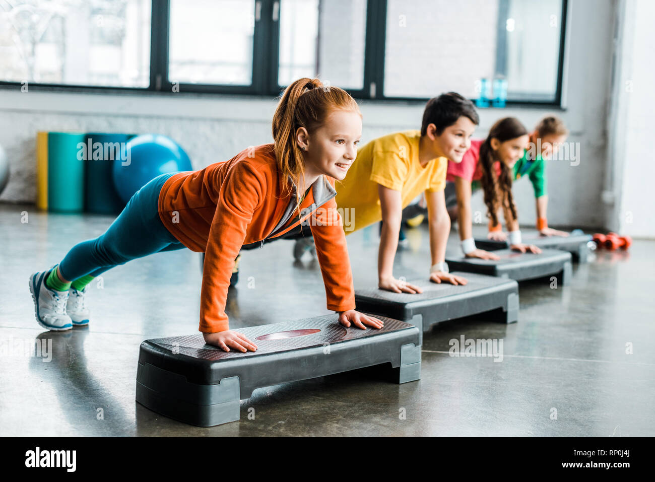 Children doing plank exercise with step platforms Stock Photo - Alamy