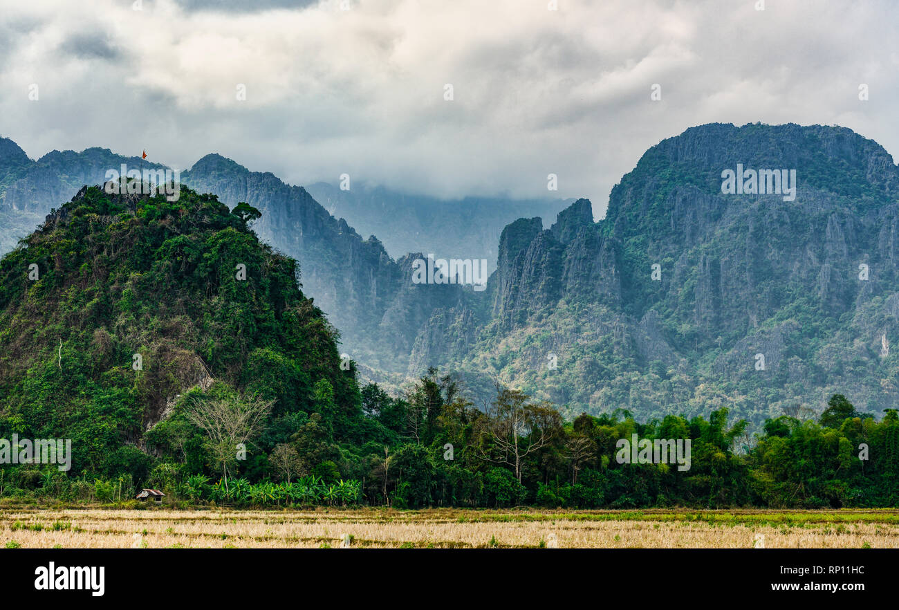 Stunning view of a some limestone mountains illuminated by some sun rays that filter through some clouds. Vang Vieng, Laos. Stock Photo
