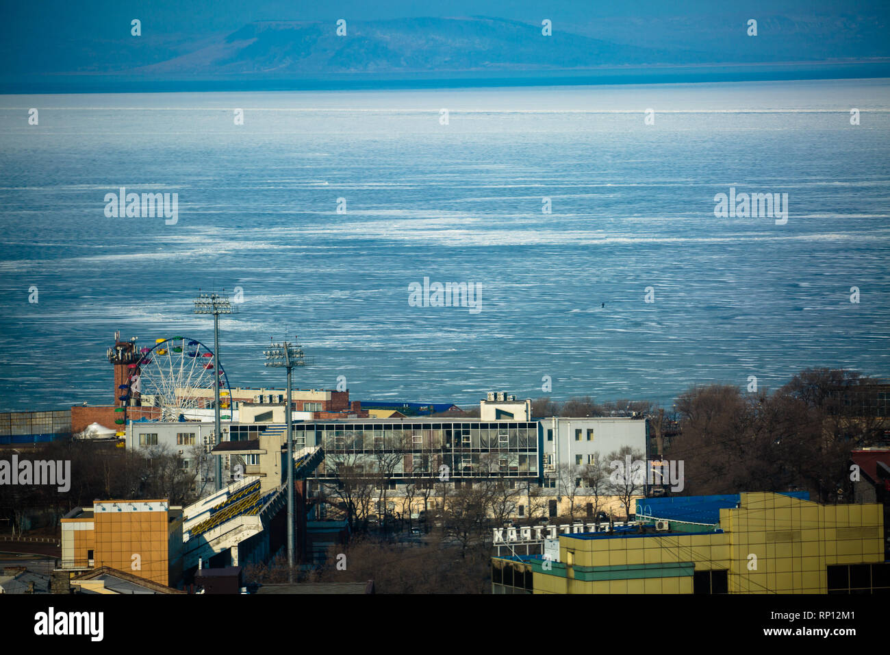 The thick ice pack sticks out from Vladivostok city in a sunny but cold winters day, Russia Stock Photo