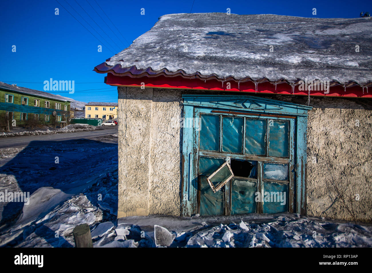 A home leans quite extensively as the permafrost below it melts, Batagay, Russia Stock Photo