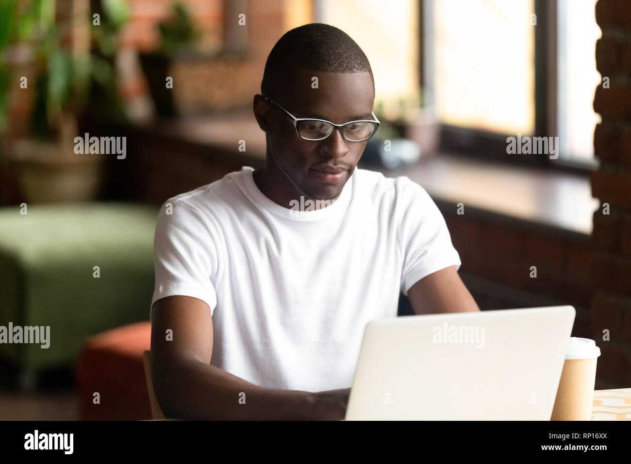Focused black millennial guy working on computer Stock Photo