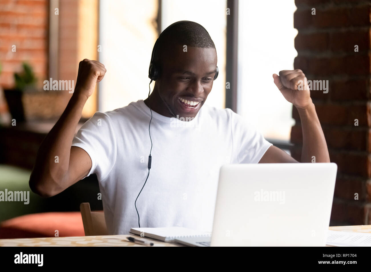 Black young man looking at computer screen feels happy Stock Photo