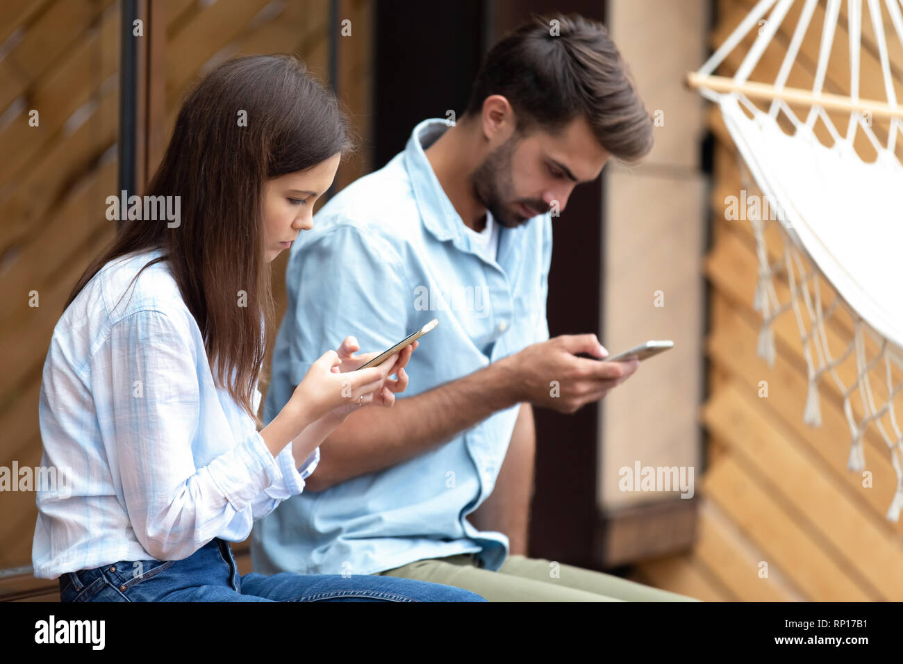 Girl and guy holding smartphones browse internet chatting online Stock Photo