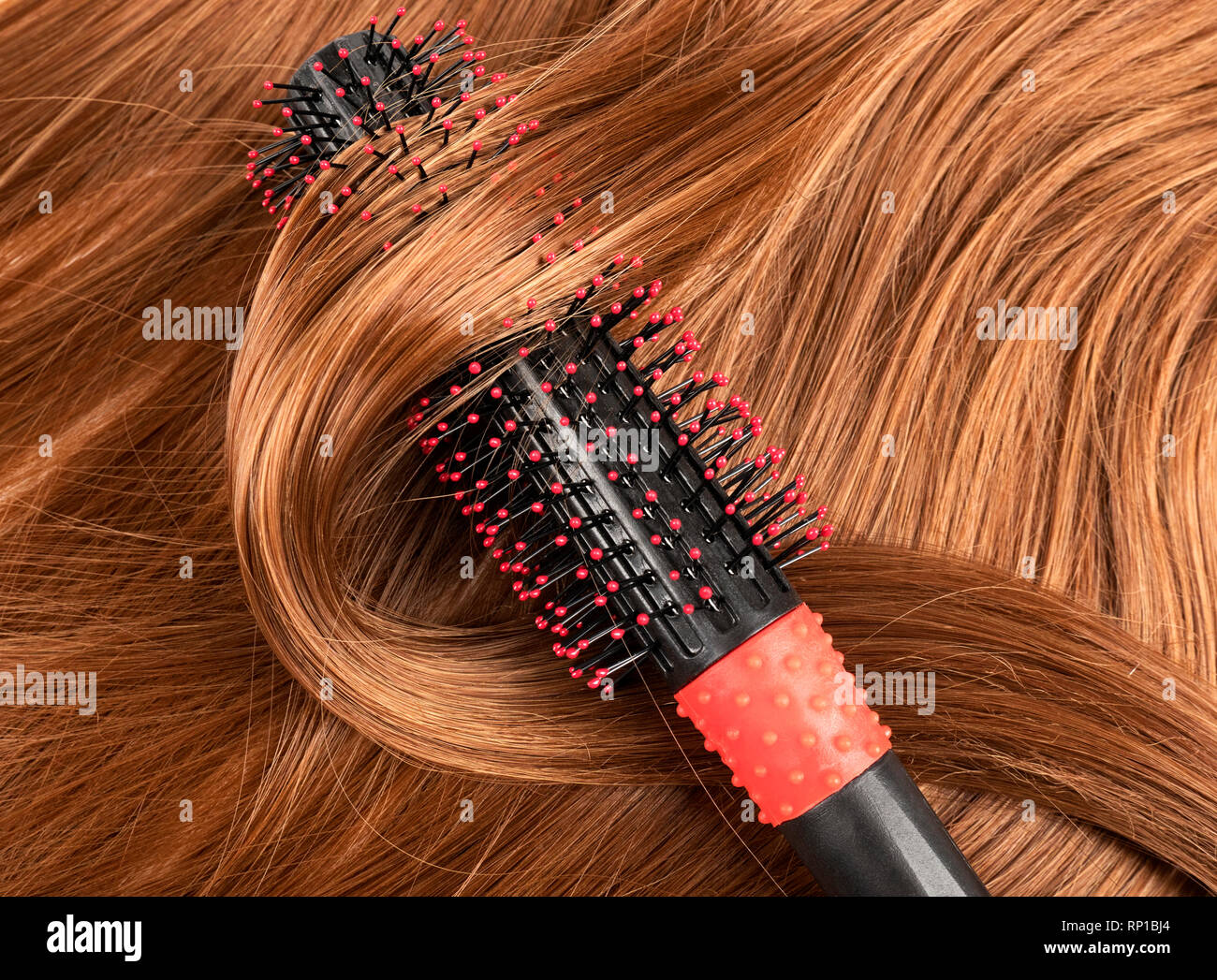 Wavy red human hair background with a comb Stock Photo