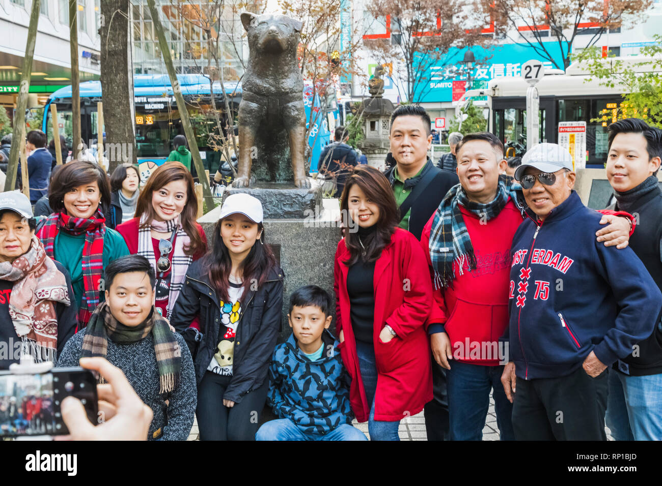 Japan, Honshu, Tokyo, Shibuya, Asian Tourists Posing with Hachiko Statue Stock Photo