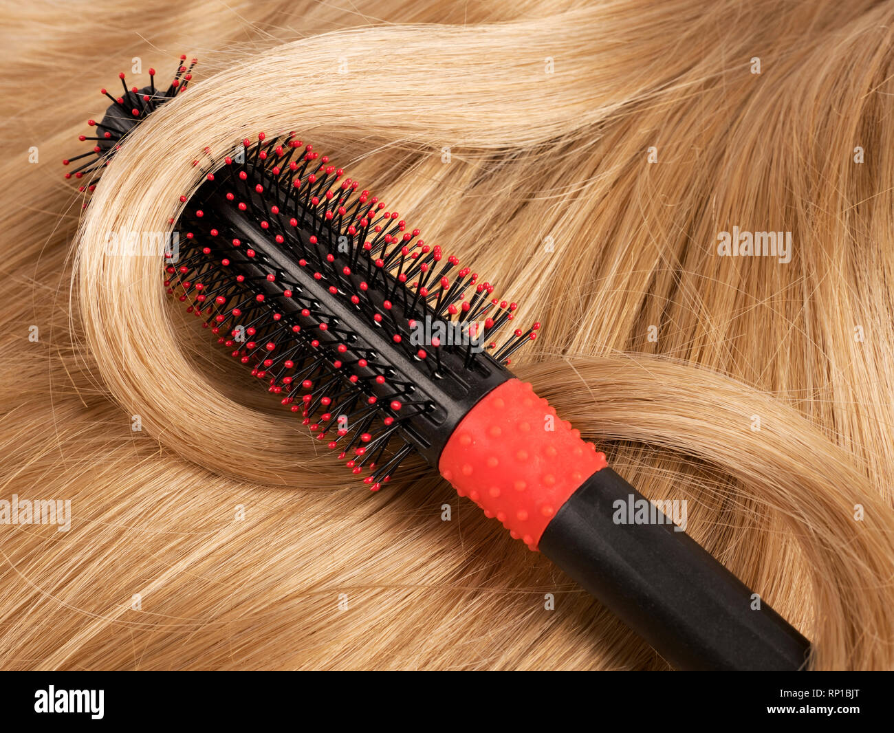 Wavy blonde human hair background with a comb Stock Photo