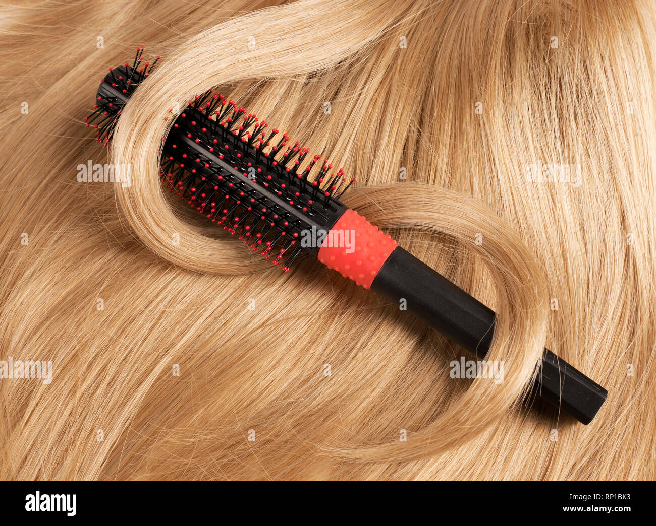 Wavy blonde human hair background with a comb Stock Photo