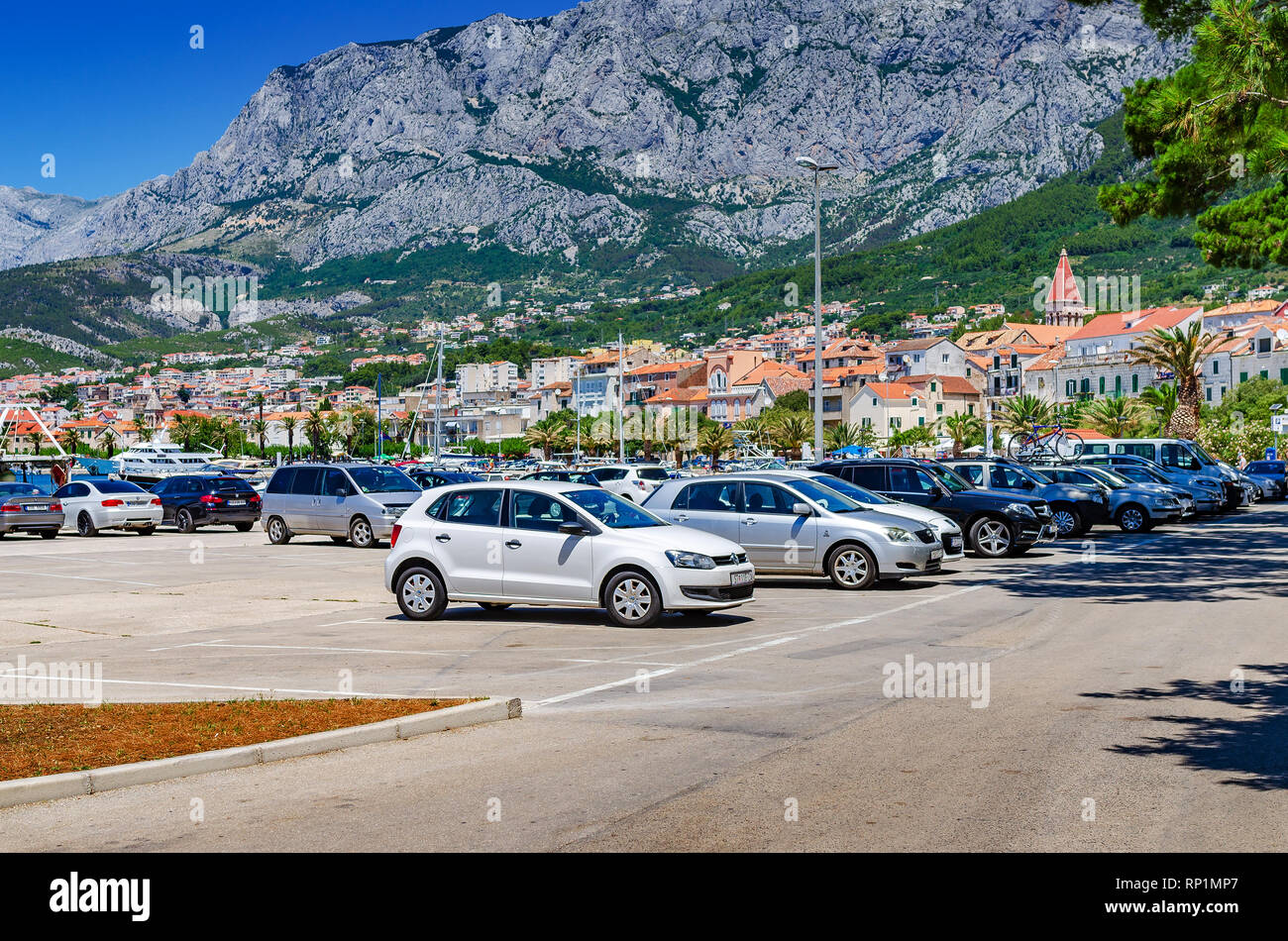 Parking of cars on the city embankment on the background of the mountains. Stock Photo