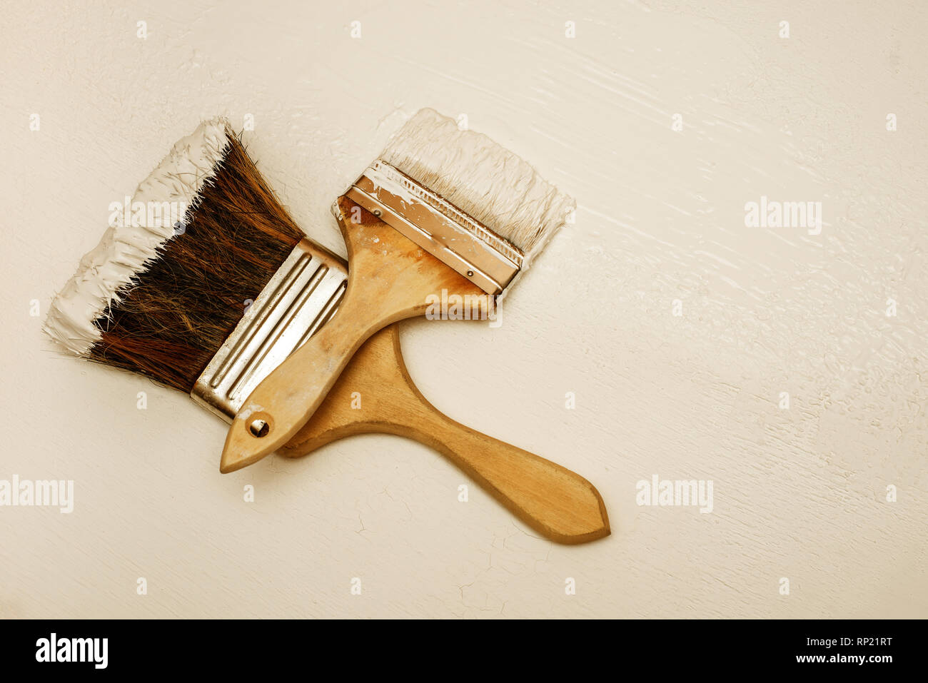 Two paint brushes lie on a white textured surface Stock Photo - Alamy