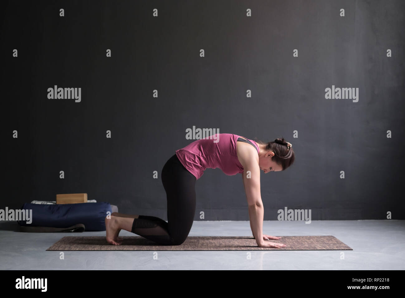 Woman working out ag doing yoga or pilates exercise. Cat, Marjaryasana Stock Photo