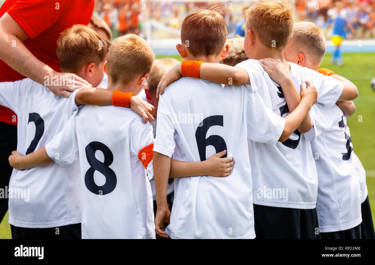 Young Boys In Football Team. Group Of Children In Soccer Team. School Football Coach’s Pregame Speech. Coaching Youth Sports Stock Photo