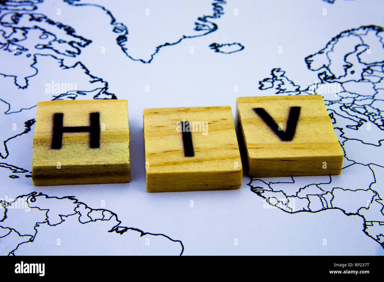 The word HIV written with wooden letters blocks above map. Health ...