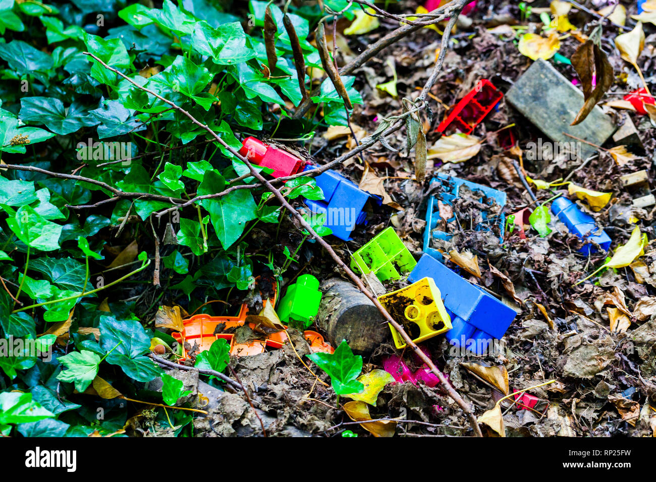 Colorful kids plastic cube toys thrown on the ground. Dirty kids toys