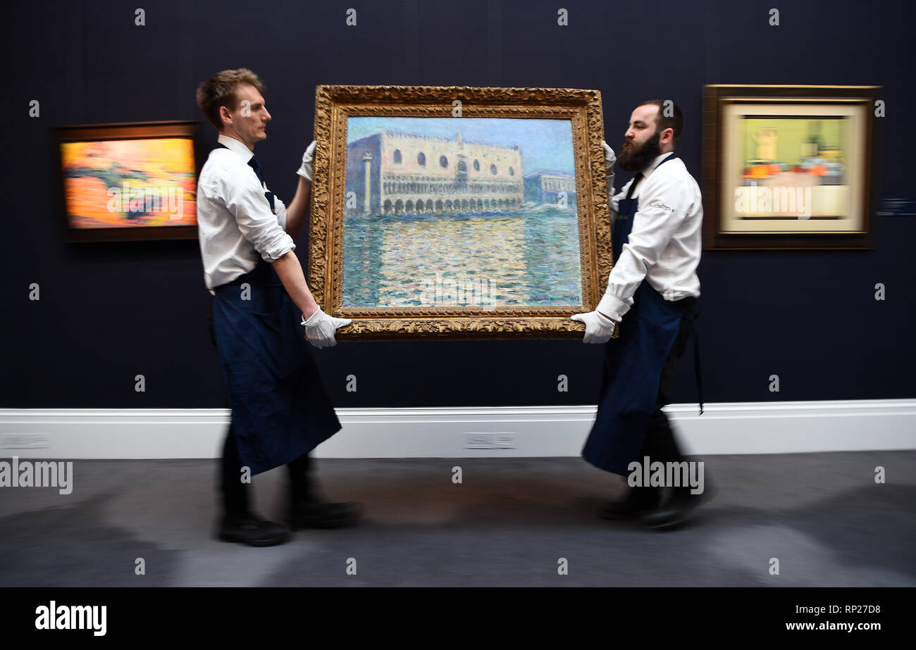 Gallery assistants adjust Le Palais Ducal by Claude Monet, during a photo call for Sotheby's Impressionist, Modern Art and Surrealist Art sales, in London. Stock Photo