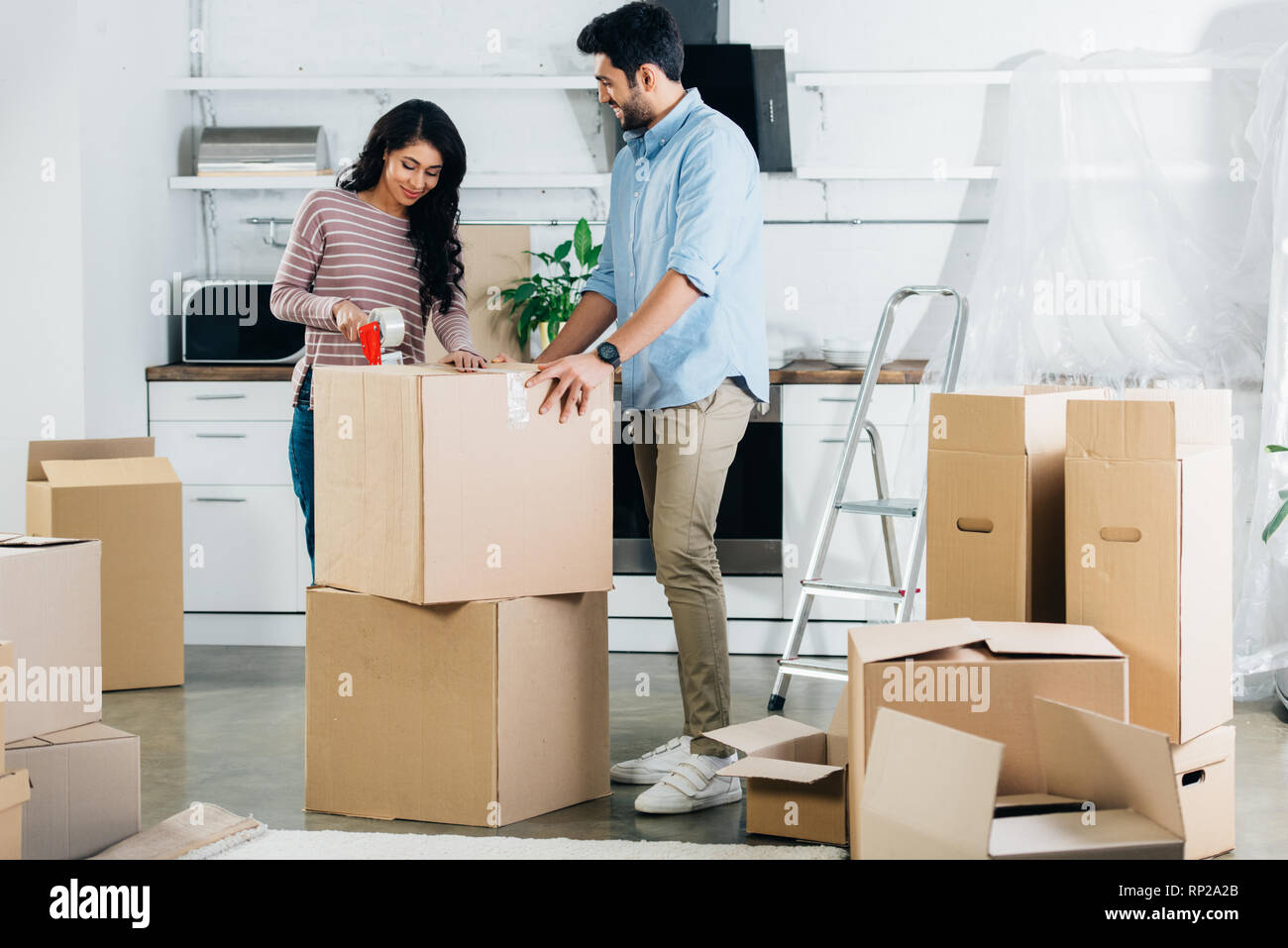 Woman suffering from backache while moving boxes. Девушка переезд. Картонная коробка возле дороги. Woman suffering from backache while moving boxes. Woman suffering from backache while moving boxes.