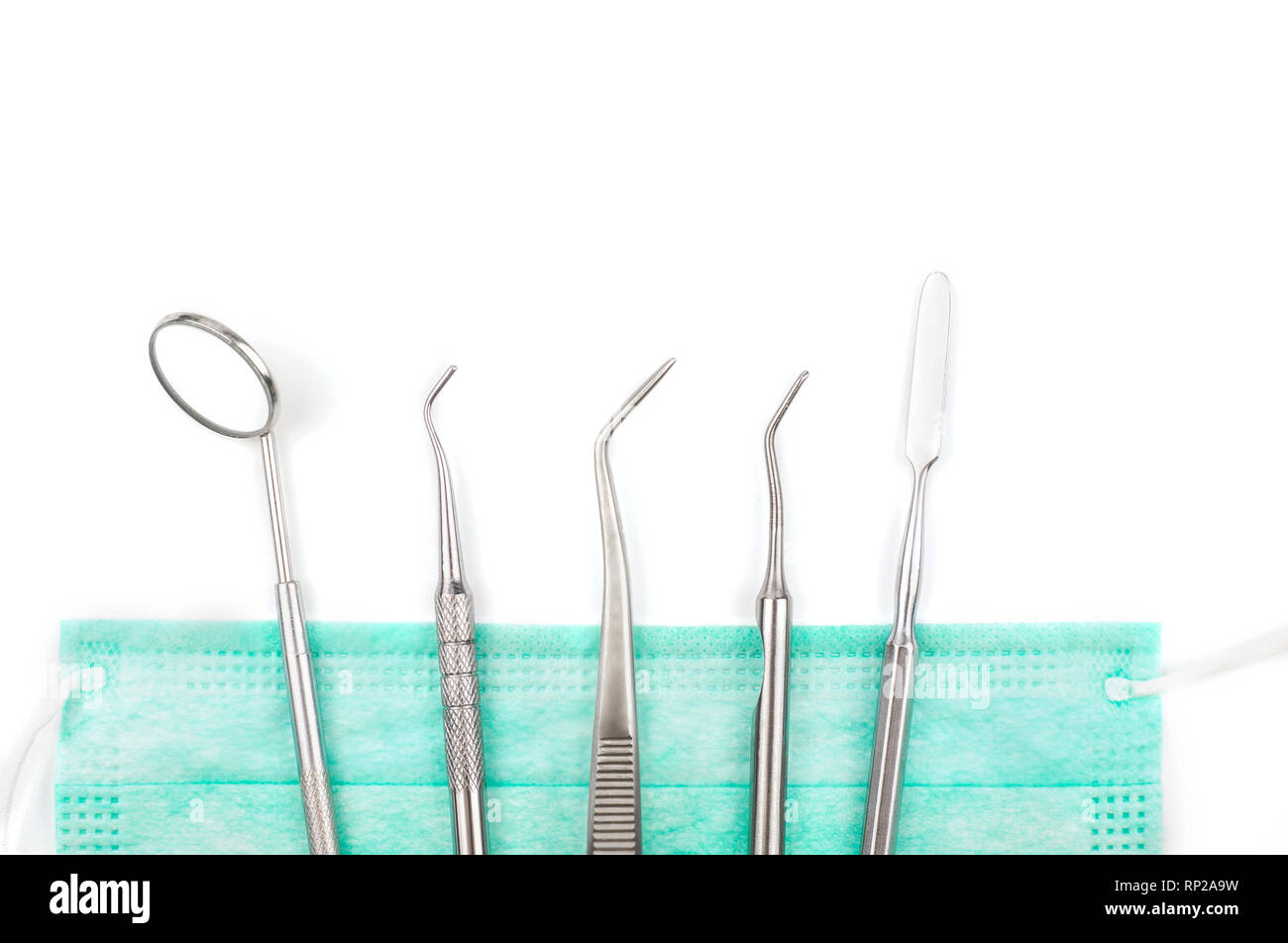 Dentist's tools and mask on white background. Stock Photo