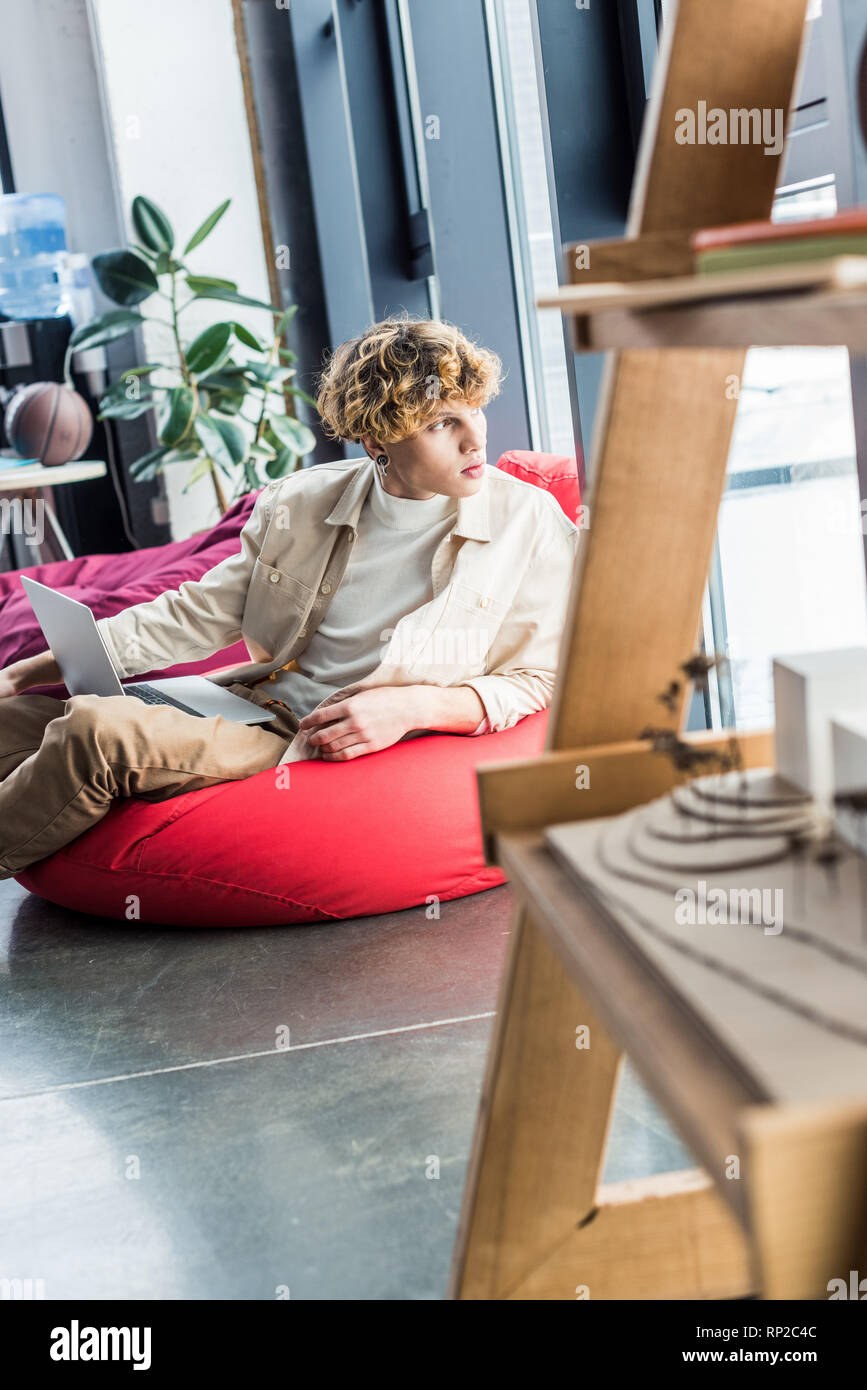 Handsome Casual Businessman Sitting In Bean Bag Chair While Using Laptop In Loft Office Stock Photo Alamy