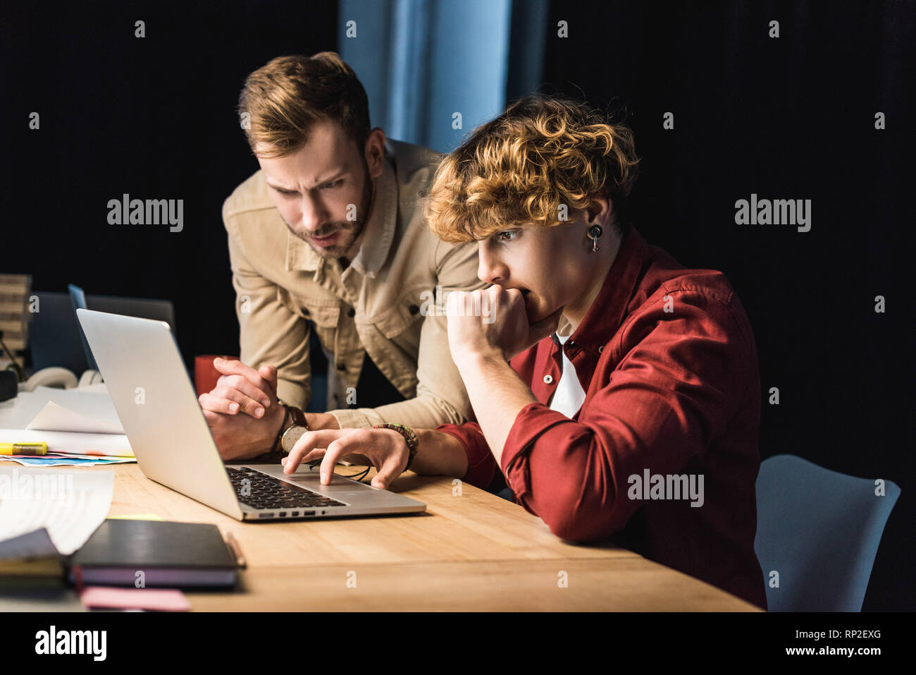 handsome confused male it specialists using laptop in office Stock Photo