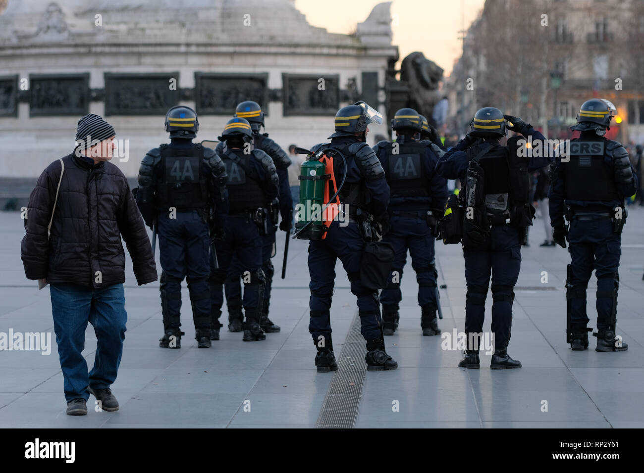 A Man Passes By French Riot Police Officers During A Yellow