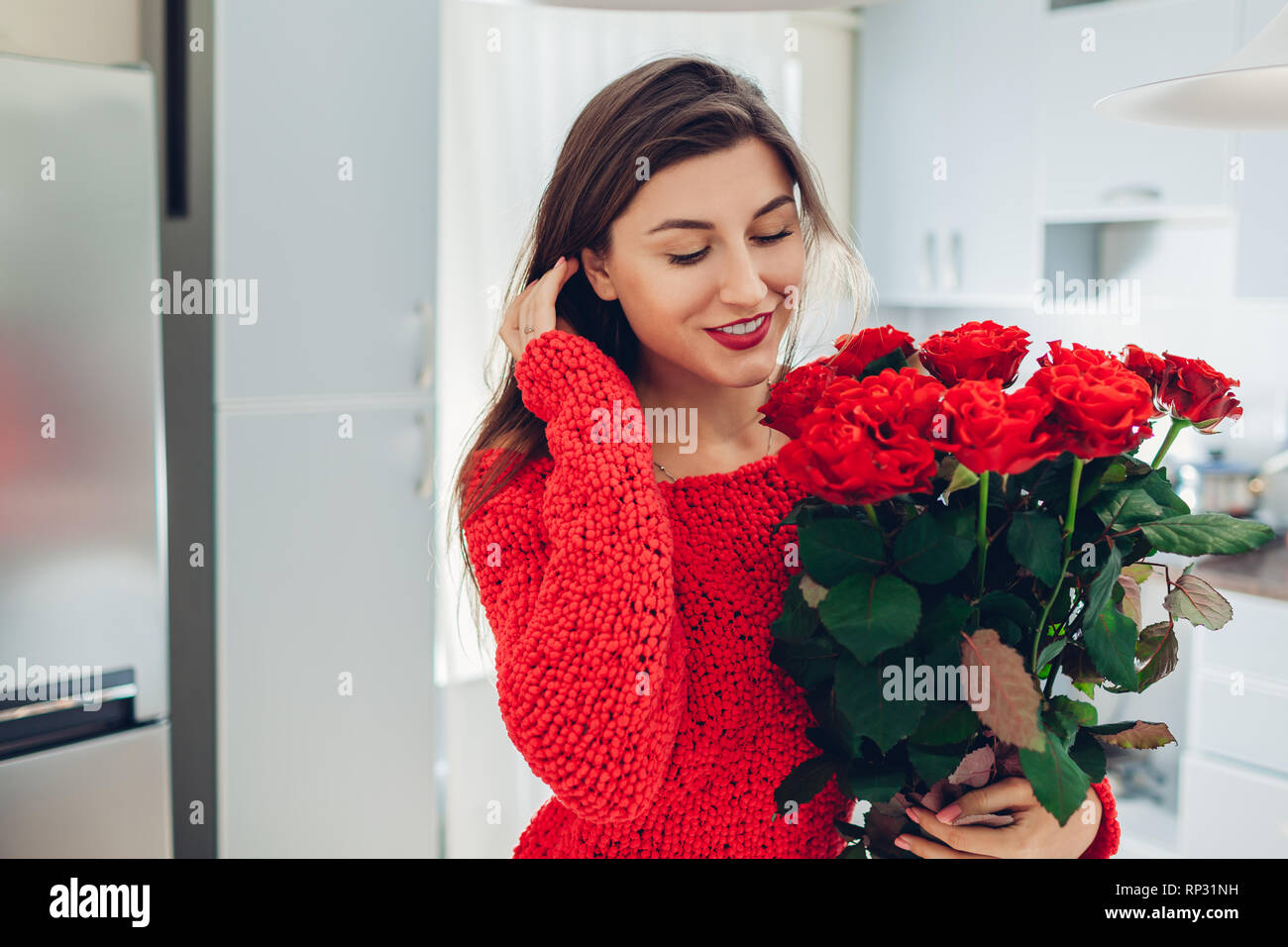 Young Woman Found Red Roses On Kitchen Happy Girl Smelling Flowers Women S Day Surprise Stock Photo Alamy