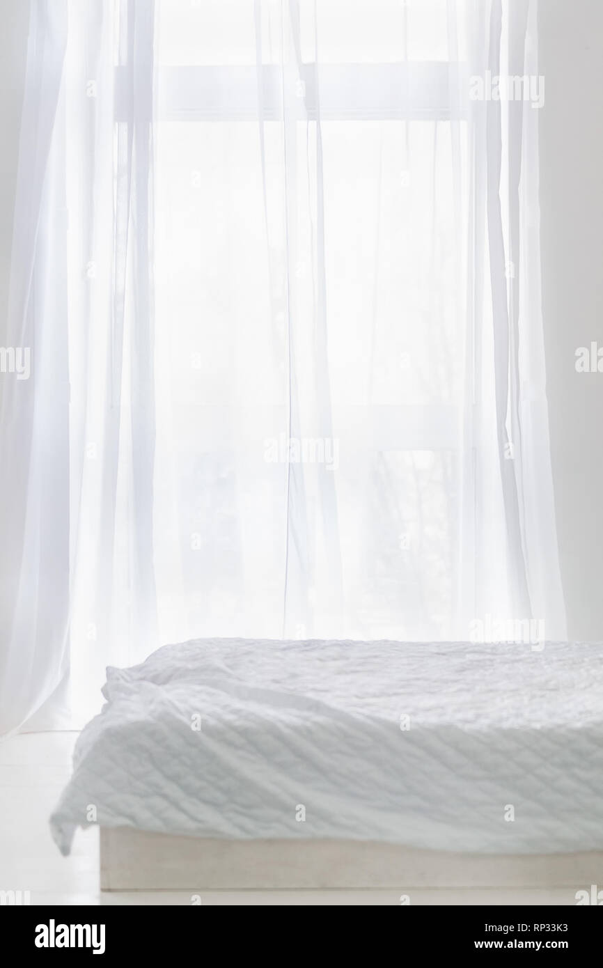Abstract white room with bed and window with white curtain Stock Photo