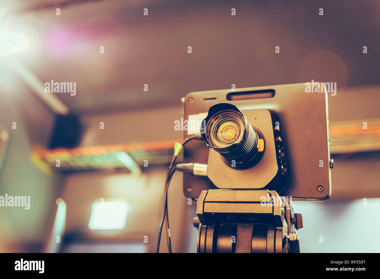 Film camera on a tripod in a television broadcasting studio, spotlights