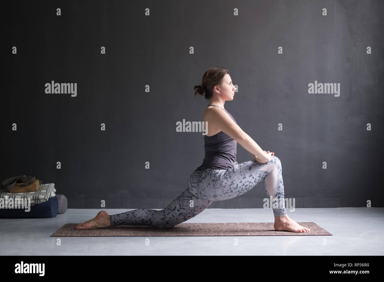 Woman doing Hatha yoga asana Anjaneyasana or low crescent lunge pose isolated, Stock Photo