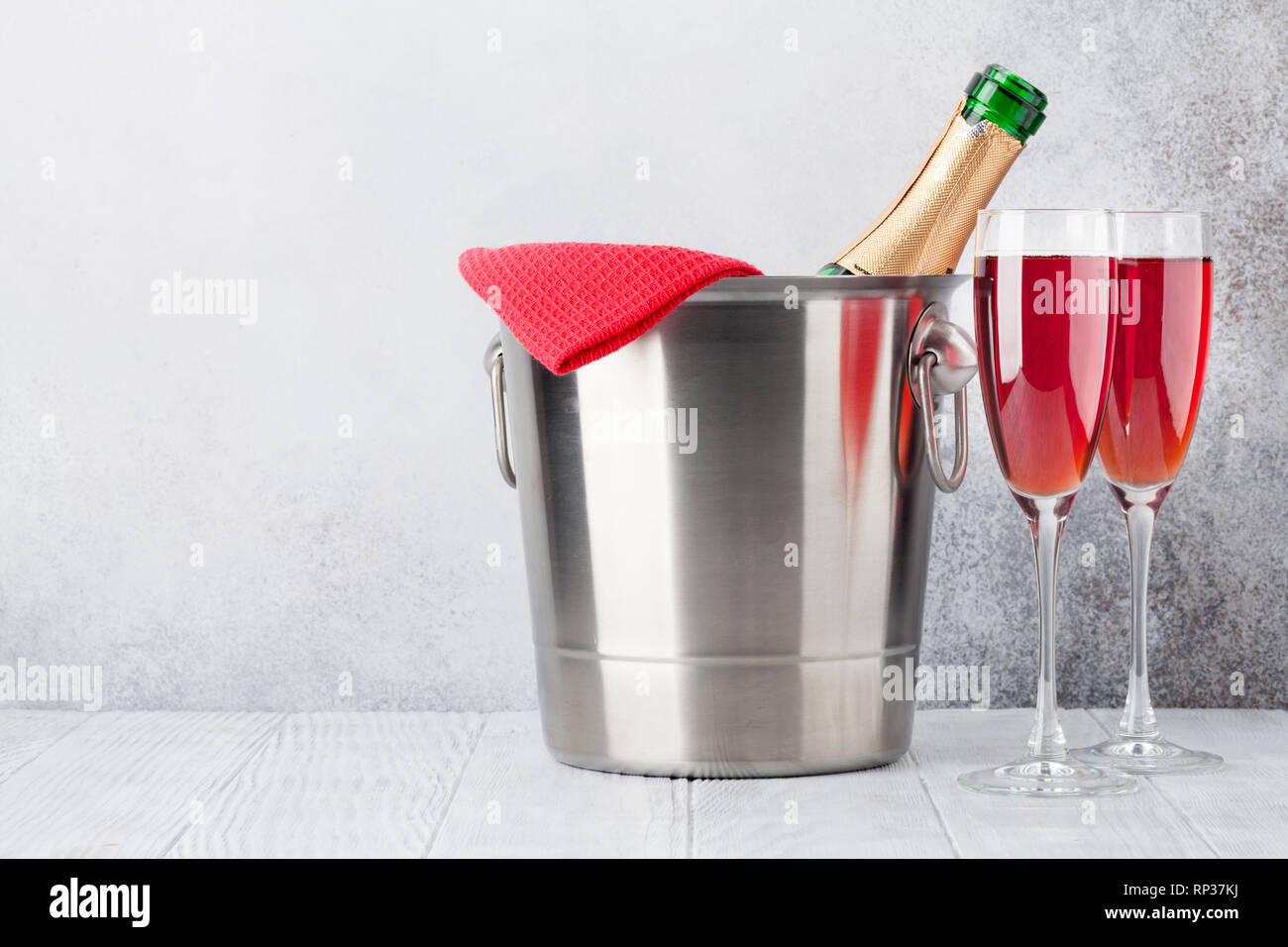 Rose wine champagne bottle in bucket and glasses. With copy space Stock Photo