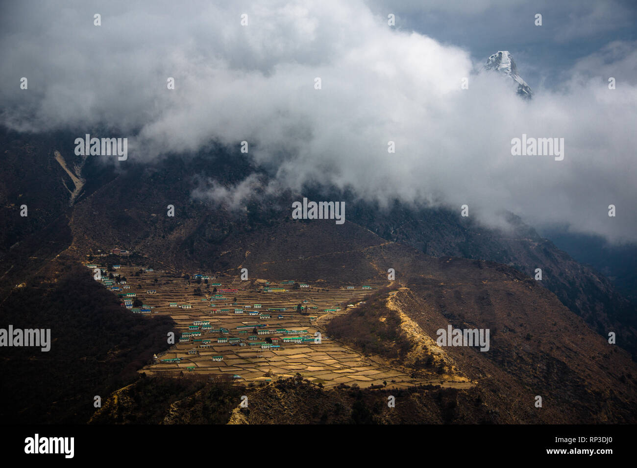 Light strikes Phortse village through misty clouds, Nepal Stock Photo
