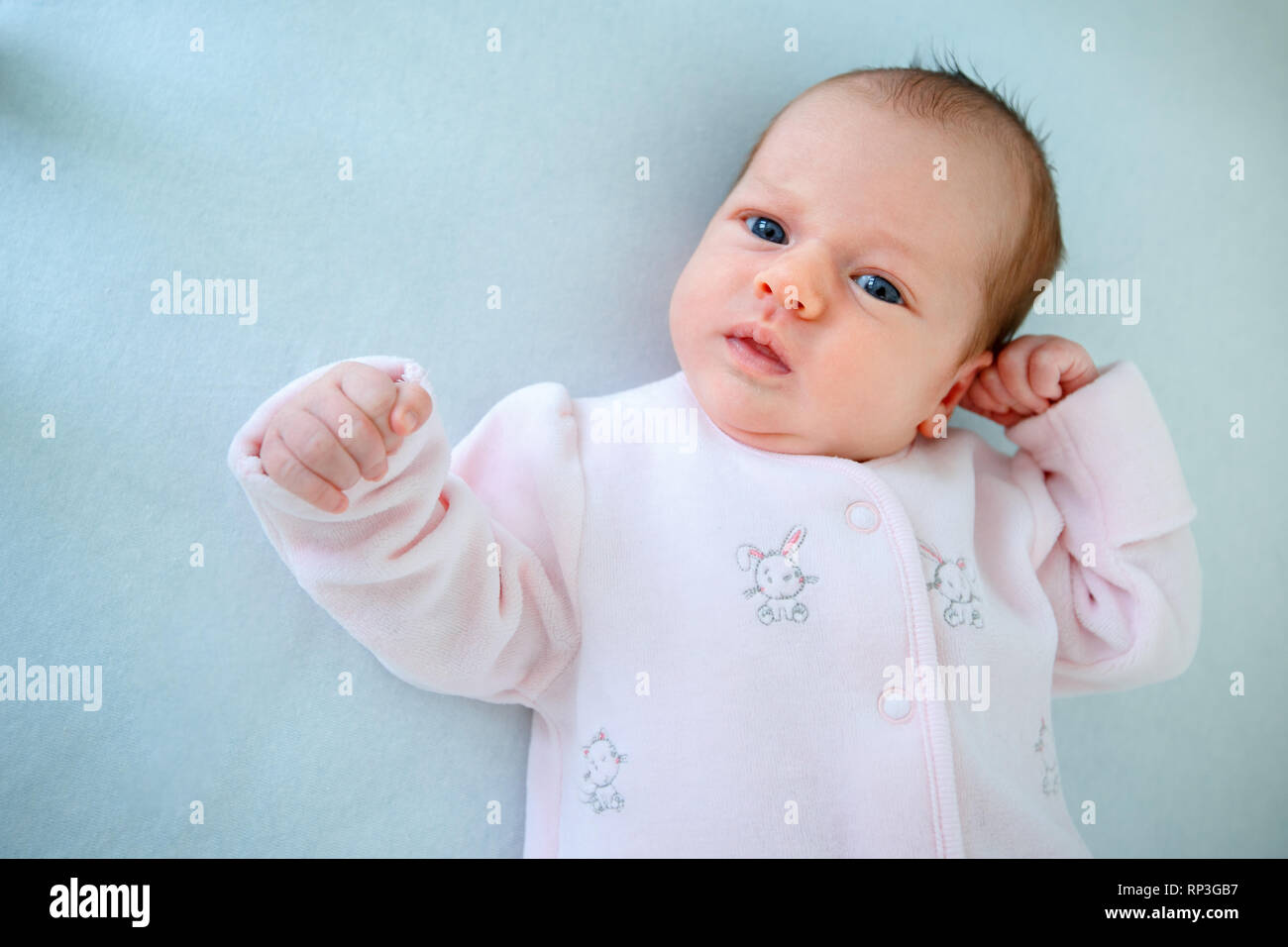 Emotional baby lying in cradle at home Stock Photo