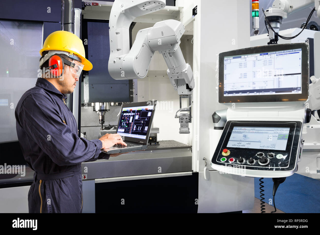 Maintenance engineer using laptop computer control automatic robotic hand with CNC machine in smart factory, Industry 4.0 concept Stock Photo