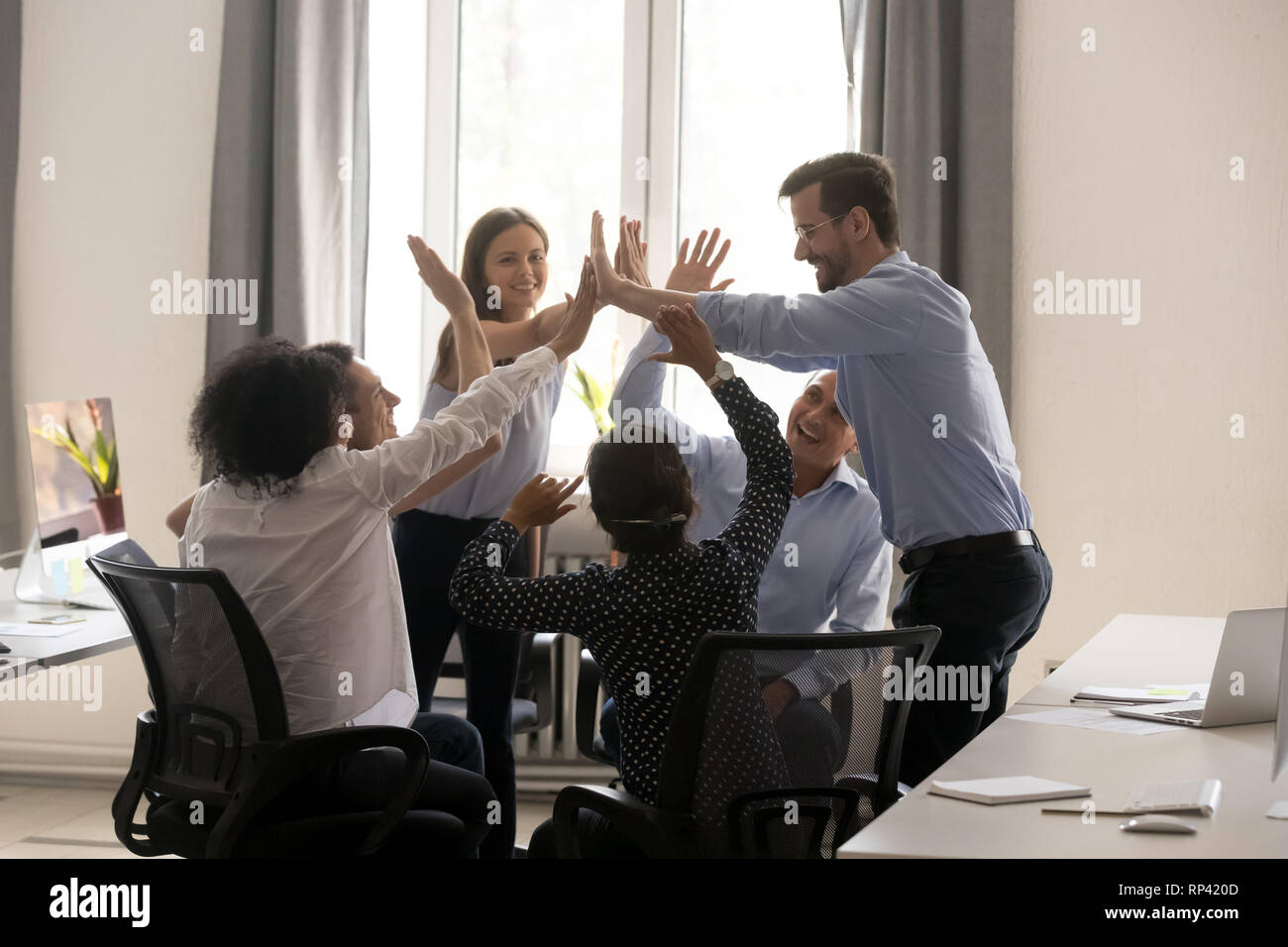 Diverse multiethnic colleagues giving high five celebrating success and ...