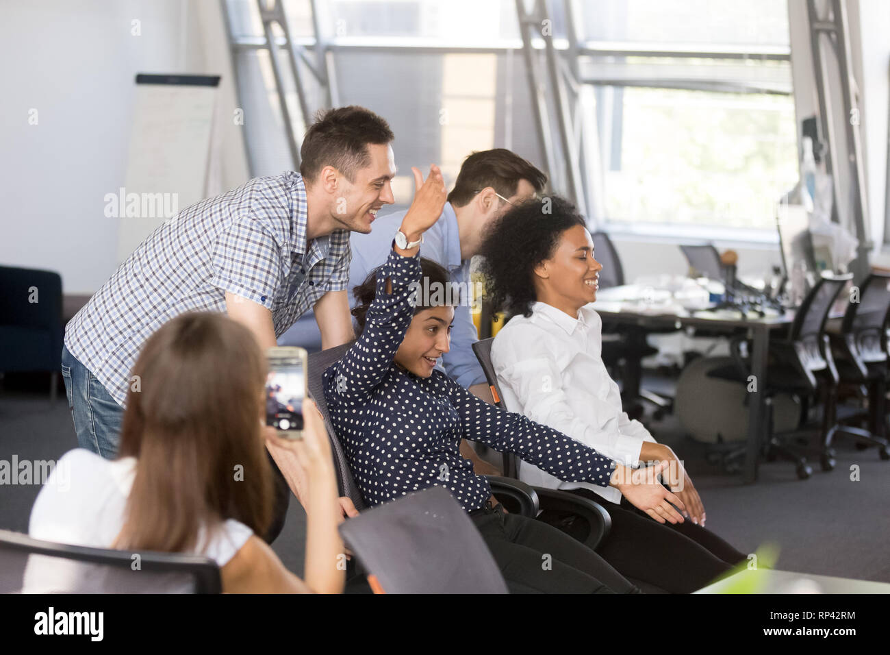 Funny office workers take a break riding on chairs have fun together with  colleagues in coworking open space during workday coworker make video for  me Stock Photo - Alamy