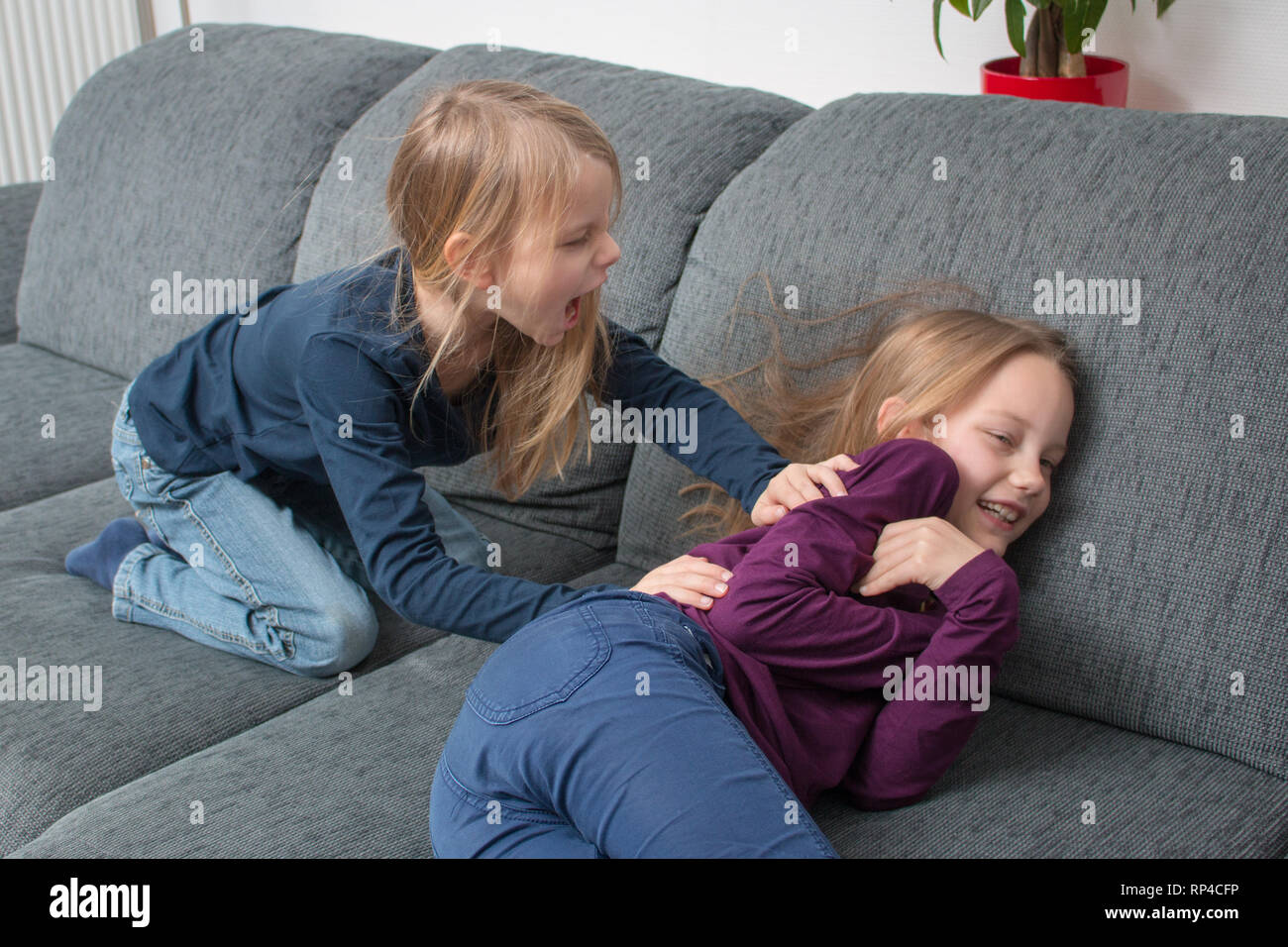Girls shouts angry at another girl and is pushing her Stock Photo