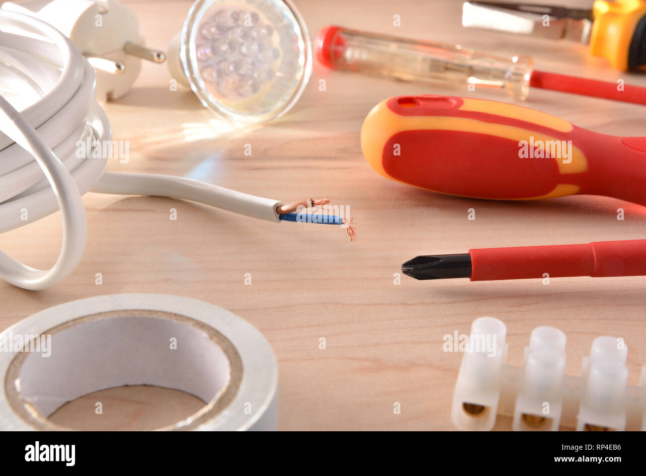 Composition of tools for electrical repairs on wooden table. Horizontal composition. Elevated view. Stock Photo