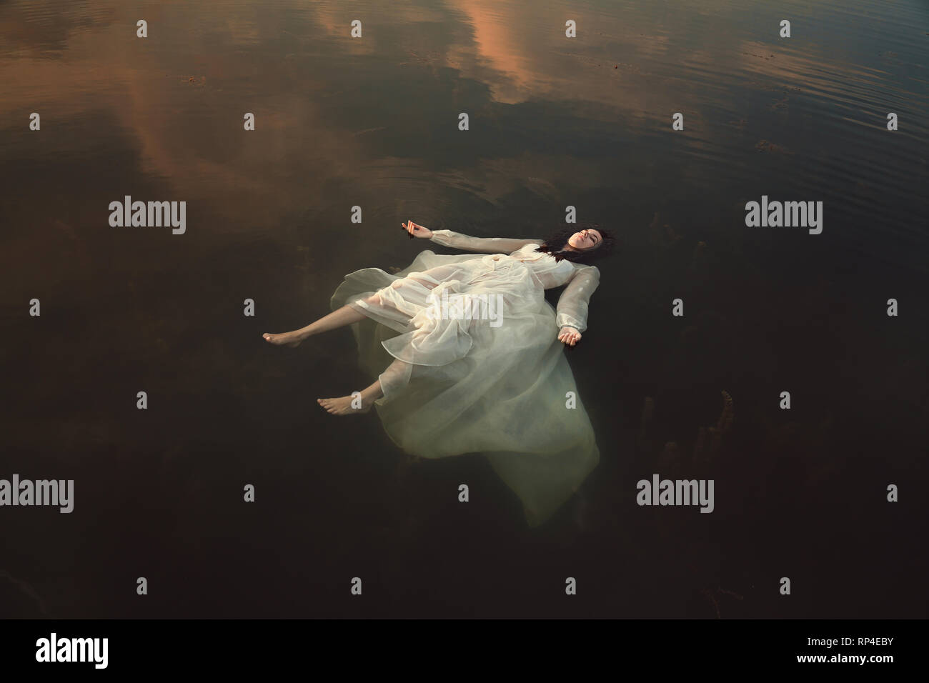 Innocent girl sleeping in dark waters Stock Photo