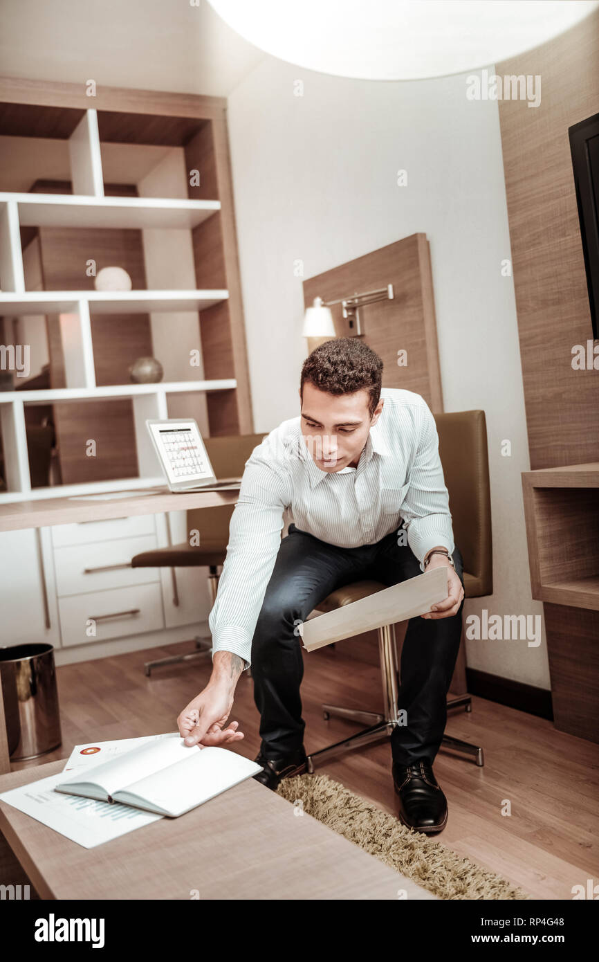 Businessman taking his notebook while working in hotel Stock Photo