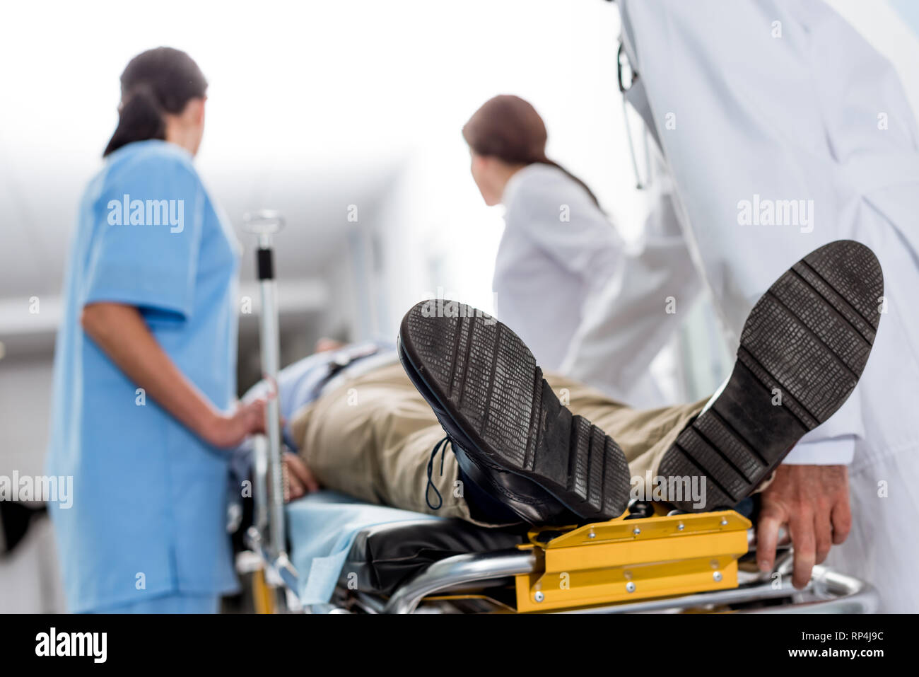 Doctors and nurse transporting unconscious patient on gurney Stock