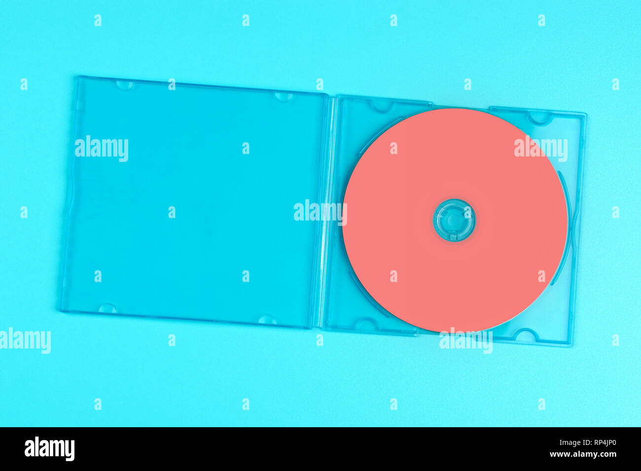 Pastel pink cd in case on pastel blue background. Color of the year 2019 - Living Coral. Stock Photo