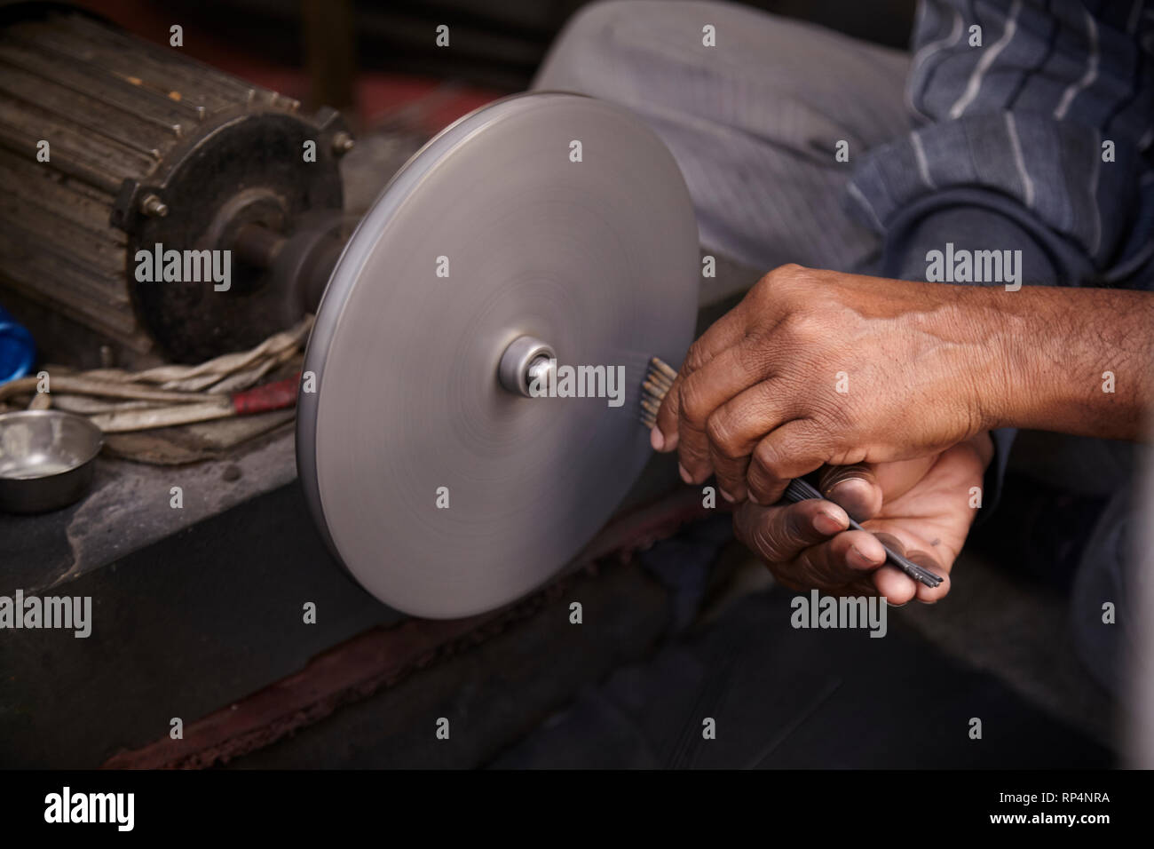 Craftsmen polishes precious stone in a small factory. Stock Photo
