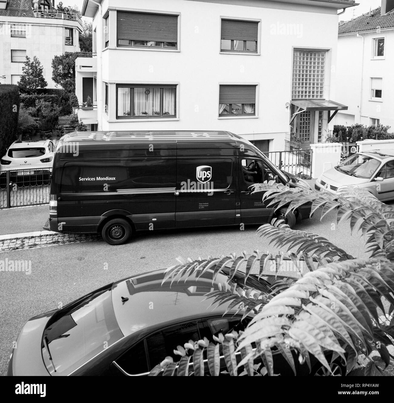 PARIS, FRANCE - AUG 24, 2017: UPS United PArcel Service brown delivery van with cardboard parcel in the hands delivering the on time delivering package parcel elevated view Stock Photo