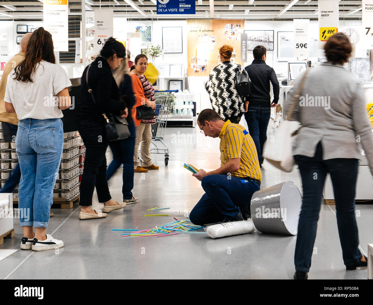 PARIS, FRANCE - SEP 2, 2017: IKEA worker employee rise from the store floor multiple objects thrown away Stock Photo