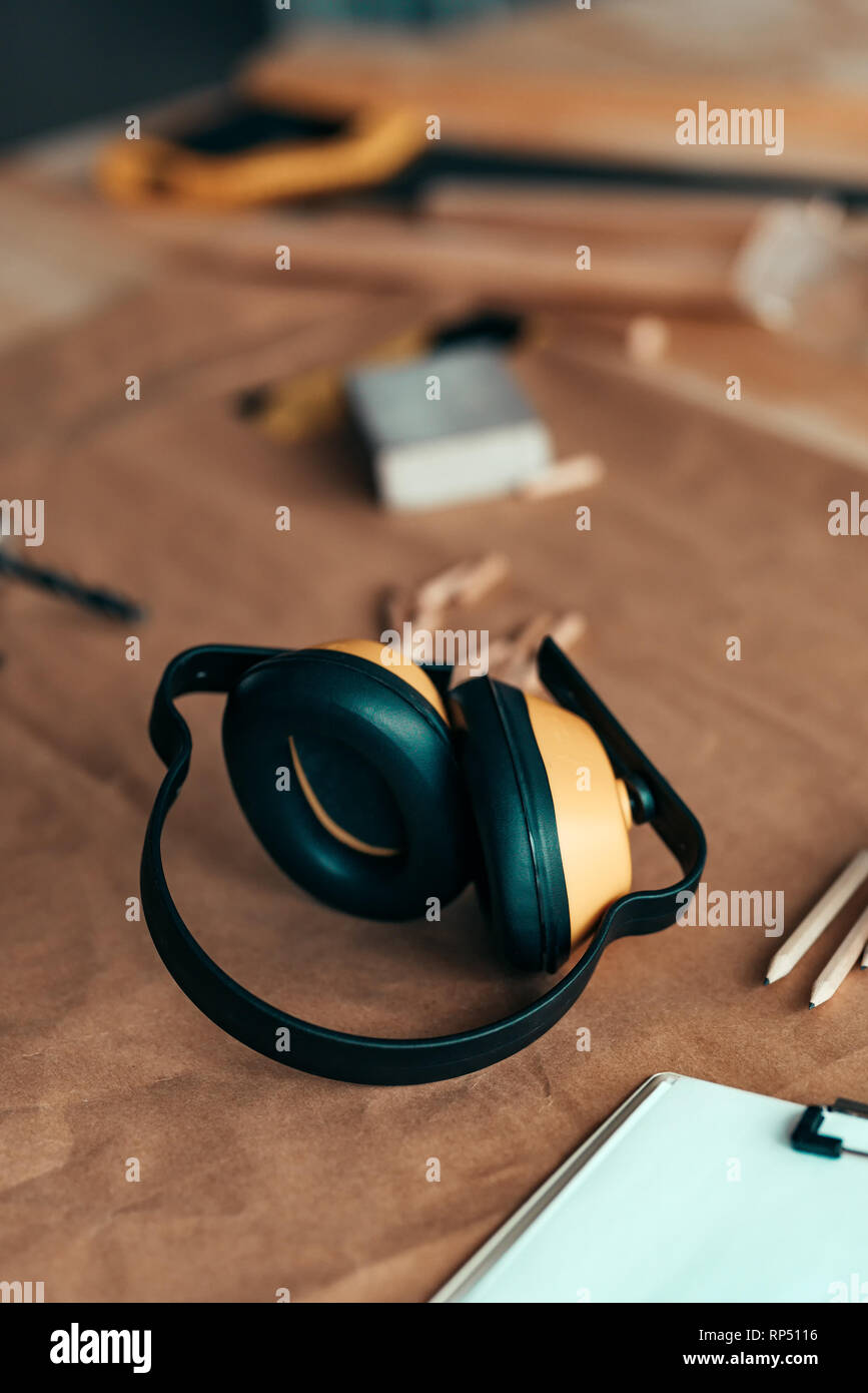 Woodwork earmuffs hearing protection equipment on carpentry desk, selective focus Stock