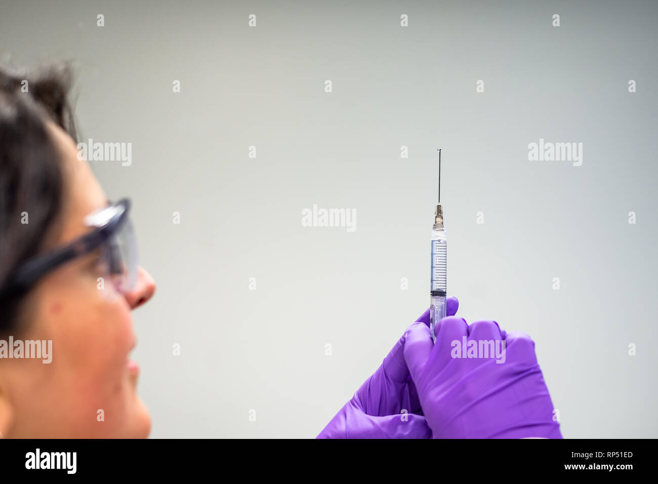 Doctor or nurse drawing injection or vaccine in syringe Stock Photo