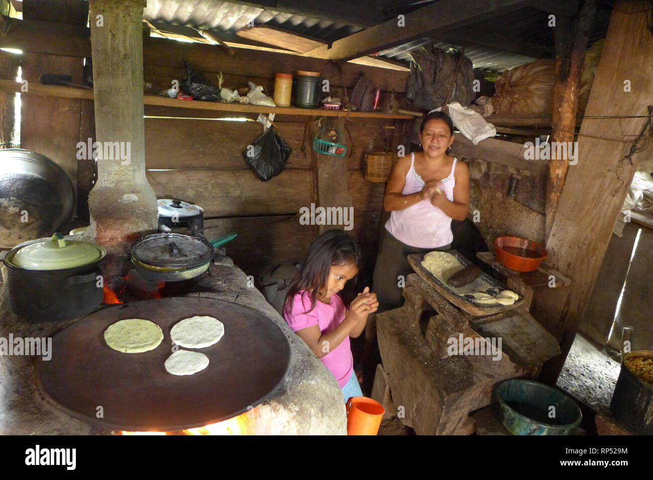 https://c8.alamy.com/comp/RP529M/el-salvador-jds-projects-in-jujutla-family-of-alvaro-tejada-60-his-wife-agripina-castillo-34-with-their-daughter-fatima-tejada-6-in-village-of-los-vasquez-jujutla-in-kitchen-making-tortillas-with-llorena-eco-woodstove-RP529M.jpg