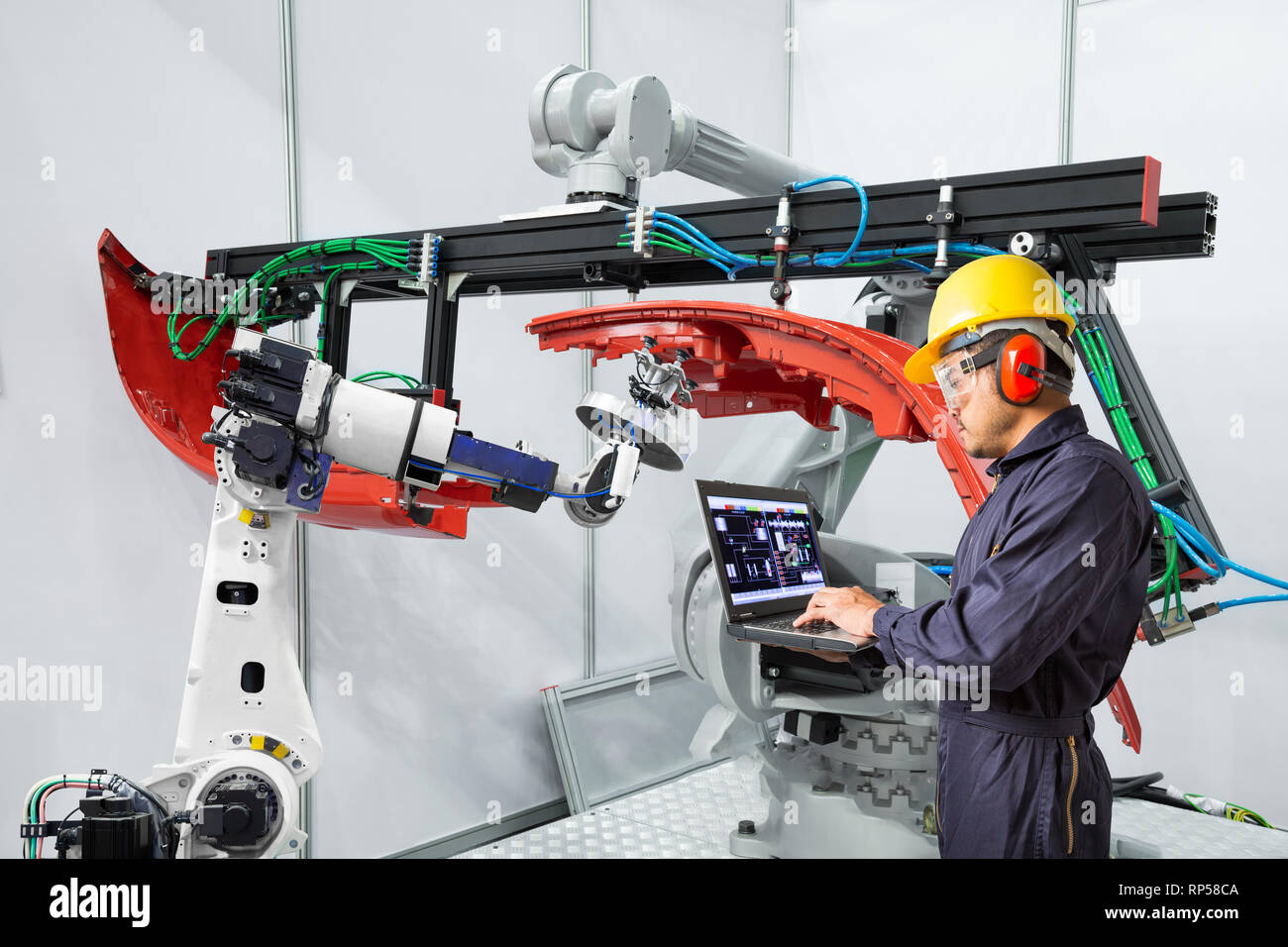 Engineer using laptop computer maintenance robot grip automotive workpiece, Smart factory concept Stock Photo