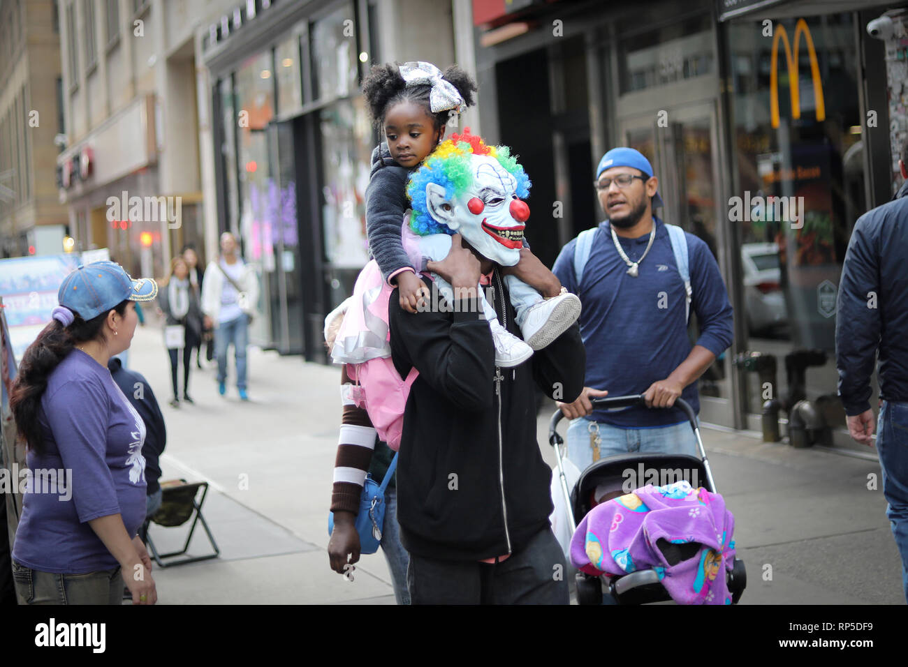 NEW YORK CITY, NY - OCTOBER 28, 2017: Unidentified father carrying his undentified daughter on his back and both dresses for halloween in New York Cit Stock Photo