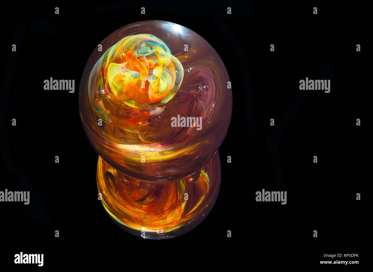 multicolored glass paperweight and reflection isolated against black Stock Photo